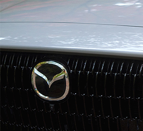 The powerful grille of the all-new Mazda CX-60 SUV with its iconic wing shape highlighted by sweeping LED headlamps.