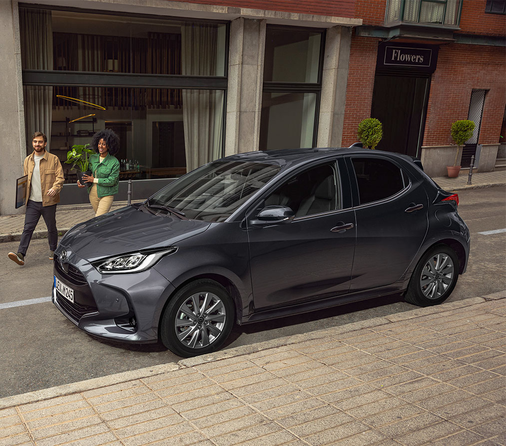 Woman Walking in Front of Mazda2 Hybrid