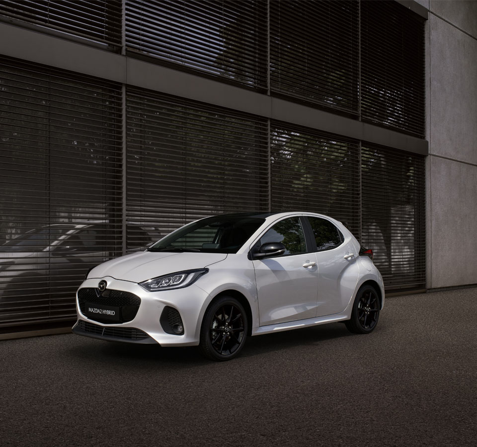 Mazda2 Hybrid parkeret foran en bygning.