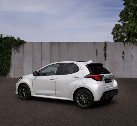 Mazda2 Hybrid i hvid parkeret på en gade.