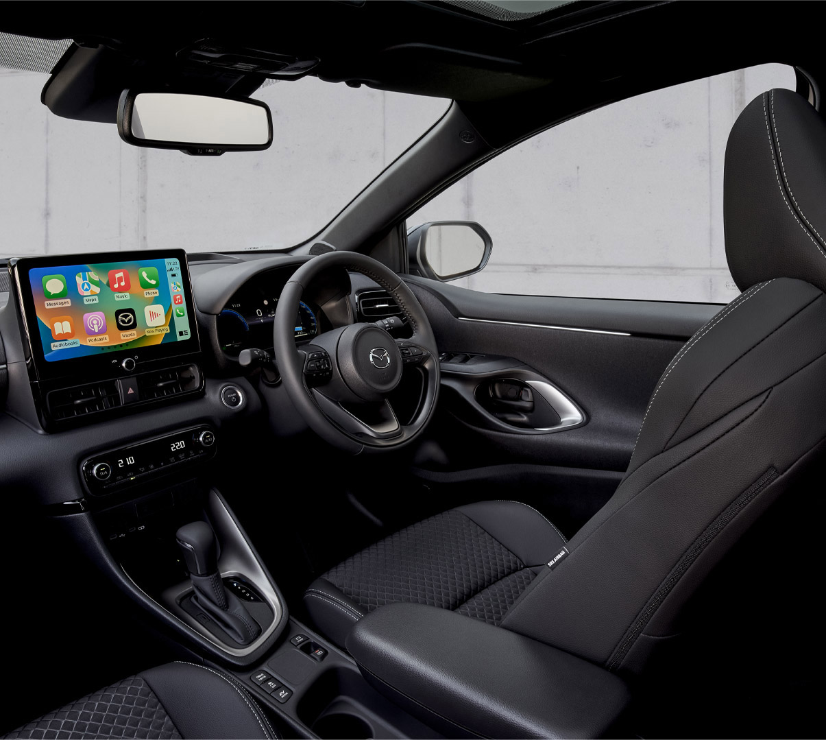 The interior of the Mazda2 Hybrid showing driver's side and dashboard panel.