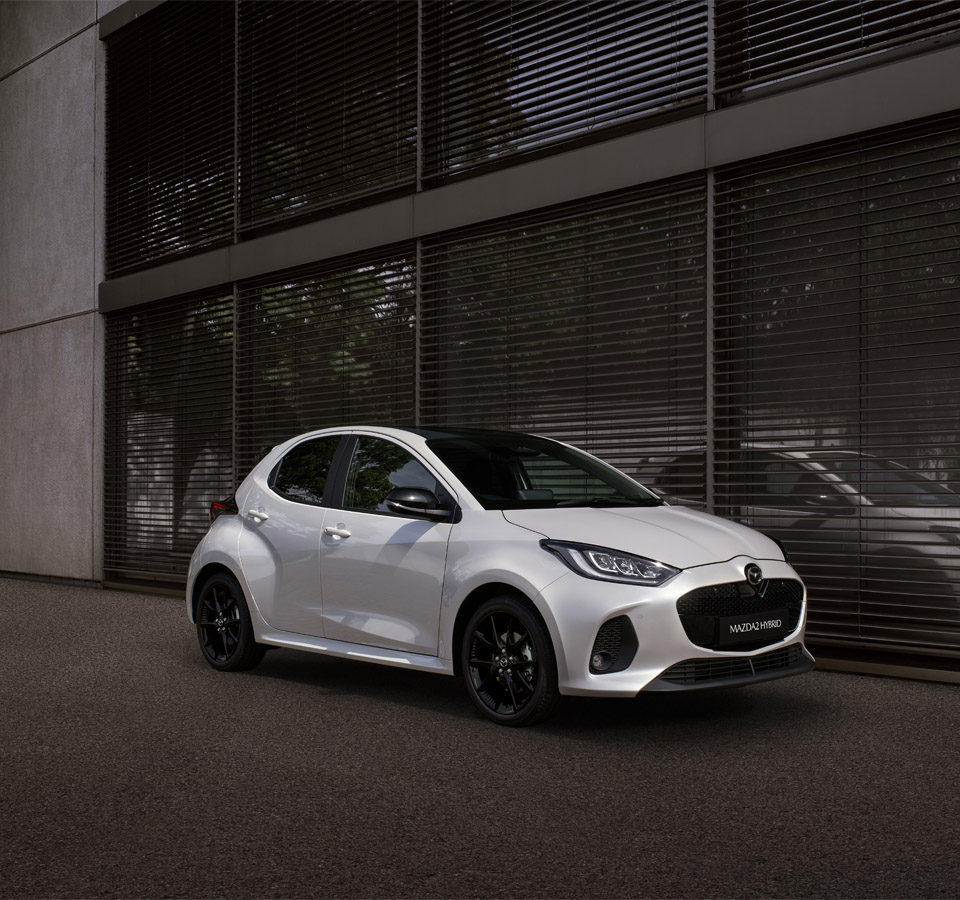 The Mazda2 Hybrid parked in front a building.