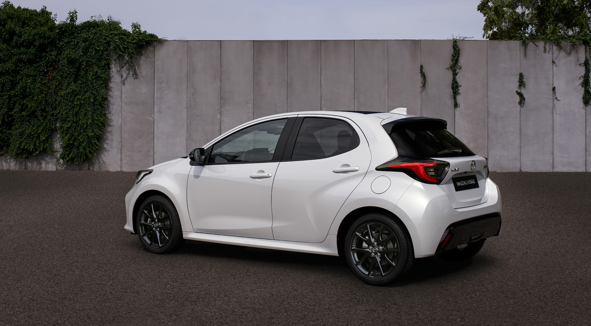 Valkoinen Mazda2 Hybrid pysäköitynä kadulle.