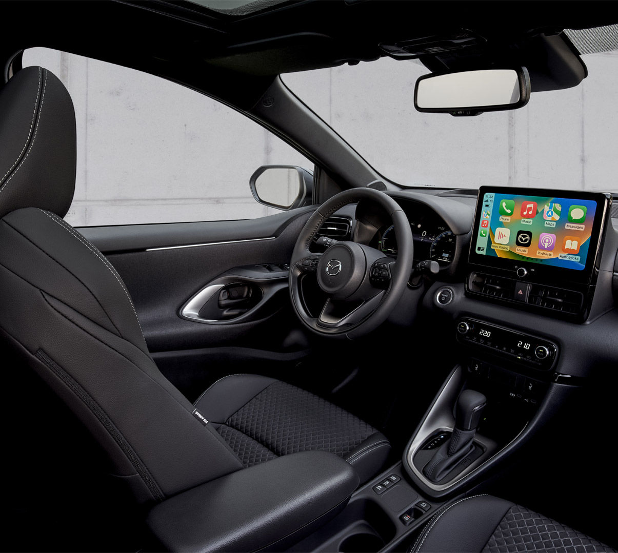 Het interieur van de Mazda2 Hybrid met de bestuurderszijde en het dashboardpaneel.