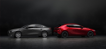 A black Mazda3 sedan parked back to back with a red Madza3 hatchback.