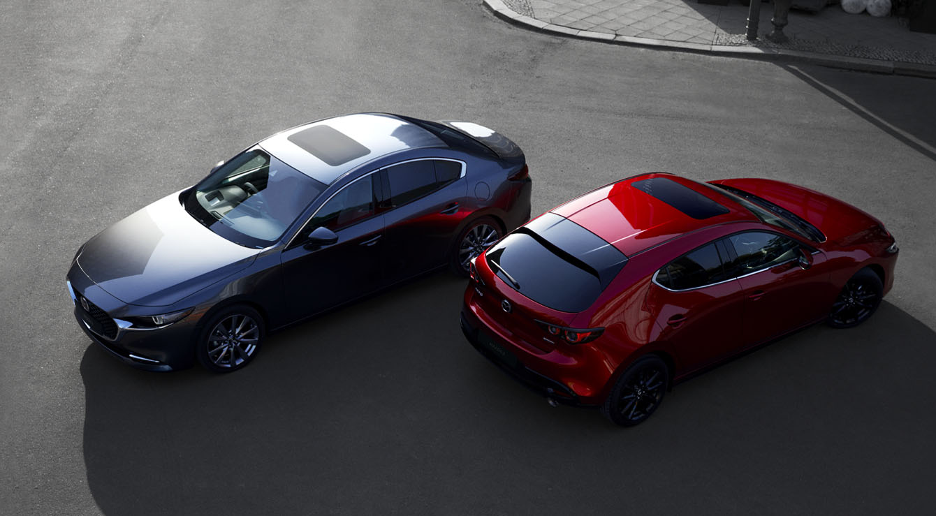 A black Mazda3 Saloon pictured facing forward and a red Madza3 hatchback seen from the back.