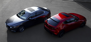 A black Mazda3 sedan pictured facing forward and a red Madza3 hatchback seen from the back.