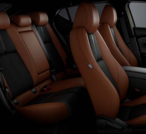 Interiorul Mazda3 Nagisa Special Version cu scaune îmbrăcate în velur negru și piele sintetică Terracotta.