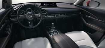 Изглед на интериора на Mazda CX-30, който показва предните седалки и таблото.