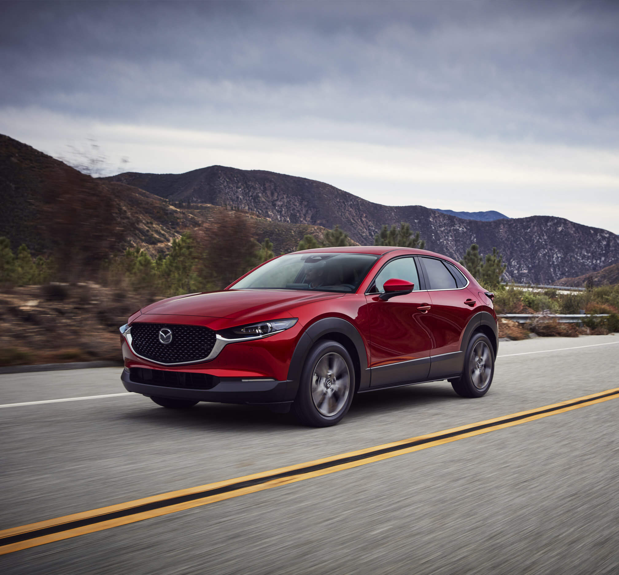 The new Mazda CX-30 driving down a road.