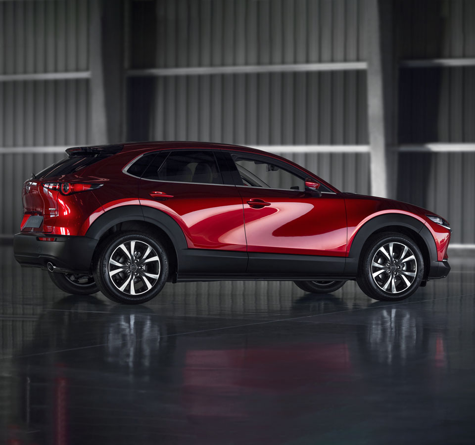 The red Mazda CX-30 pictured from the side.