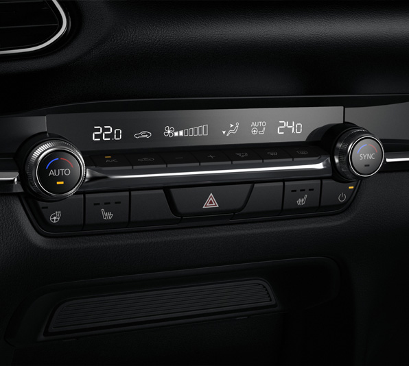 Les boutons de commande ronds du système de climatisation automatique de la Mazda CX-30.