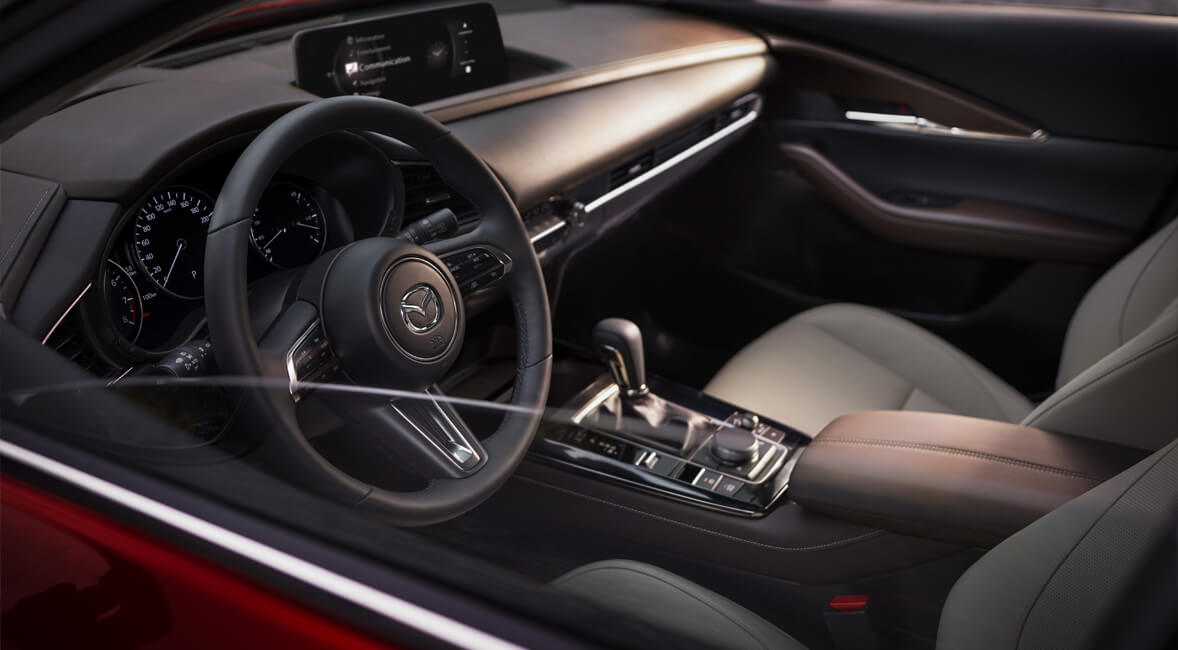 Een foto van het dashboard en stuurwiel van de Mazda CX-30.