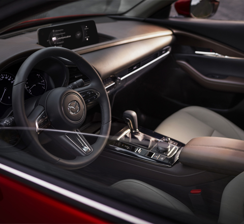 Een foto van het dashboard en stuurwiel van de Mazda CX-30.