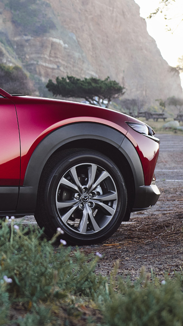 Et nærbillede af et af hjulene på en rød Mazda CX-30.