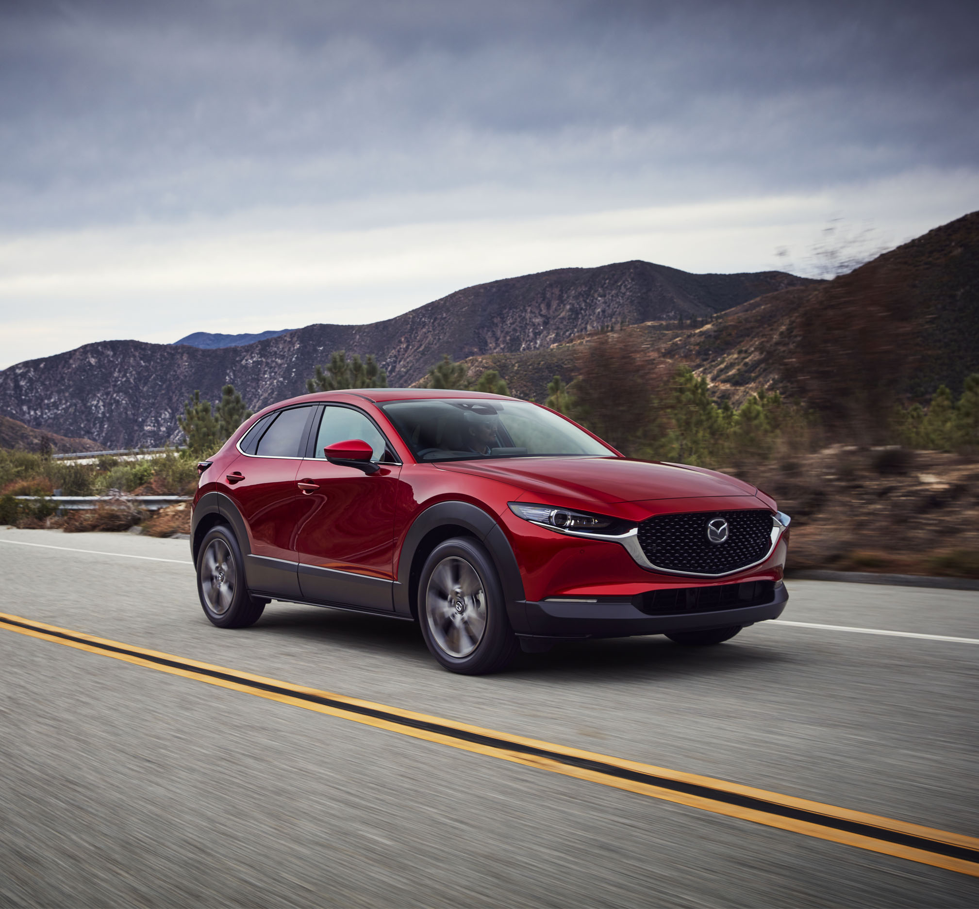 The new Mazda CX-30 driving down a road.