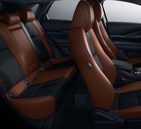 Interieur van de Mazda CX-30 Nagisa Special Version met zwart suède en Terracotta zetelbekleding in kunstleder.