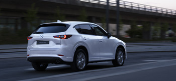A white Mazda CX-5 running down the road.