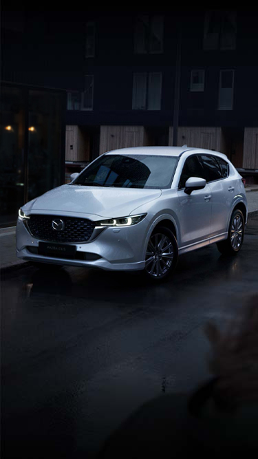 Um Mazda CX-5 branco estacionado na cidade.