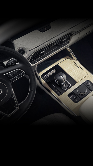 Der Innenraum des aufladbaren Hybrid-SUV Mazda CX-60 ist mit Ahornholz und japanischen Stoffen verkleidet.