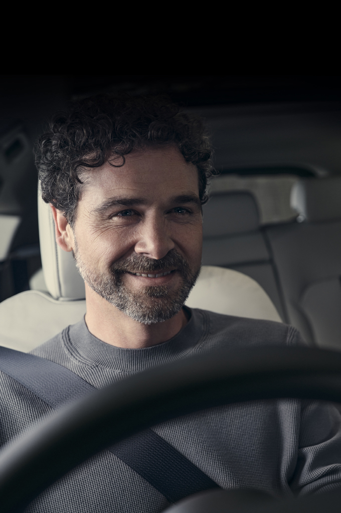 A smiling man pictured in the driver’s seat of the all-new Mazda CX-60 SUV.