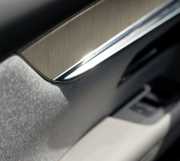 Il bracciolo della portiera anteriore della Mazda CX-60 rifinito in vero legno d’acero