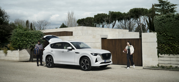 Zaparkovaná bílá Mazda CX-60, plug-in hybrid, s venku stojícím mužem a dívkou s basketbalovým míčem.