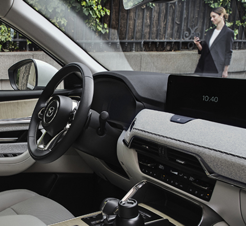 La calle de una ciudad, vista desde los ojos del pasajero del nuevo SUV híbrido enchufable Mazda CX-60.