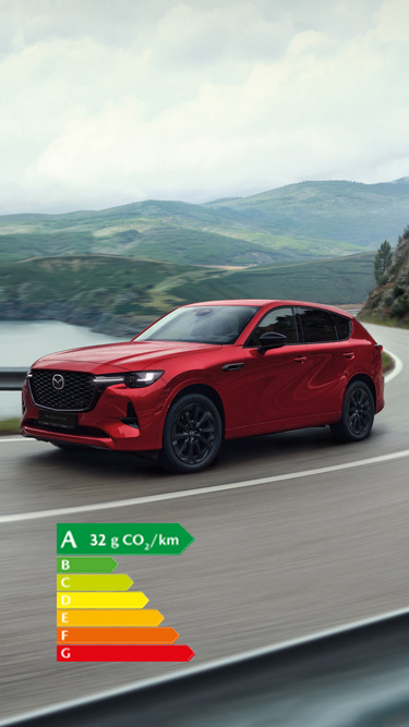 Un SUV hybride rechargeable Mazda CX-60 rouge roulant dans un virage sur une autoroute côtière.