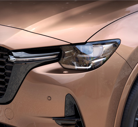 A close-up of the front LED headlights of the Mazda CX-80.