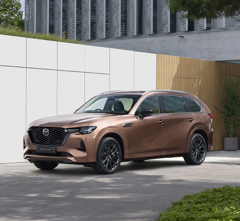 The Mazda CX-80 SUV parked in front of a house.