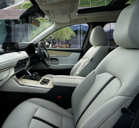 The interior of the Mazda CX-80 SUV and its comfortable white front seats.