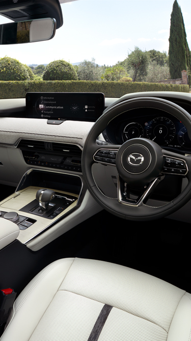 The steering wheel features the Mazda CX-80 emblem, and the dashboard with a digital display screen.