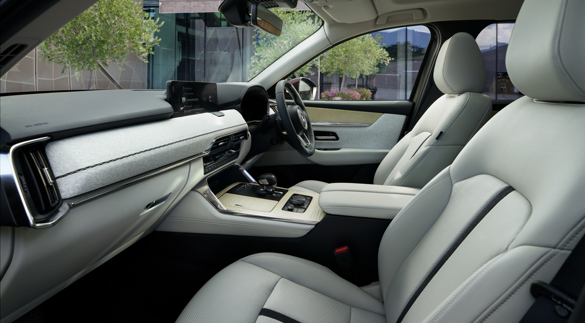 The interior of the Mazda CX-80 SUV and its comfortable white front seats.