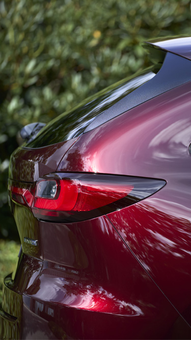 Close-up van de achterkant van een rode Mazda CX-80 SUV waarbij het design van de achterlichten wordt benadrukt.