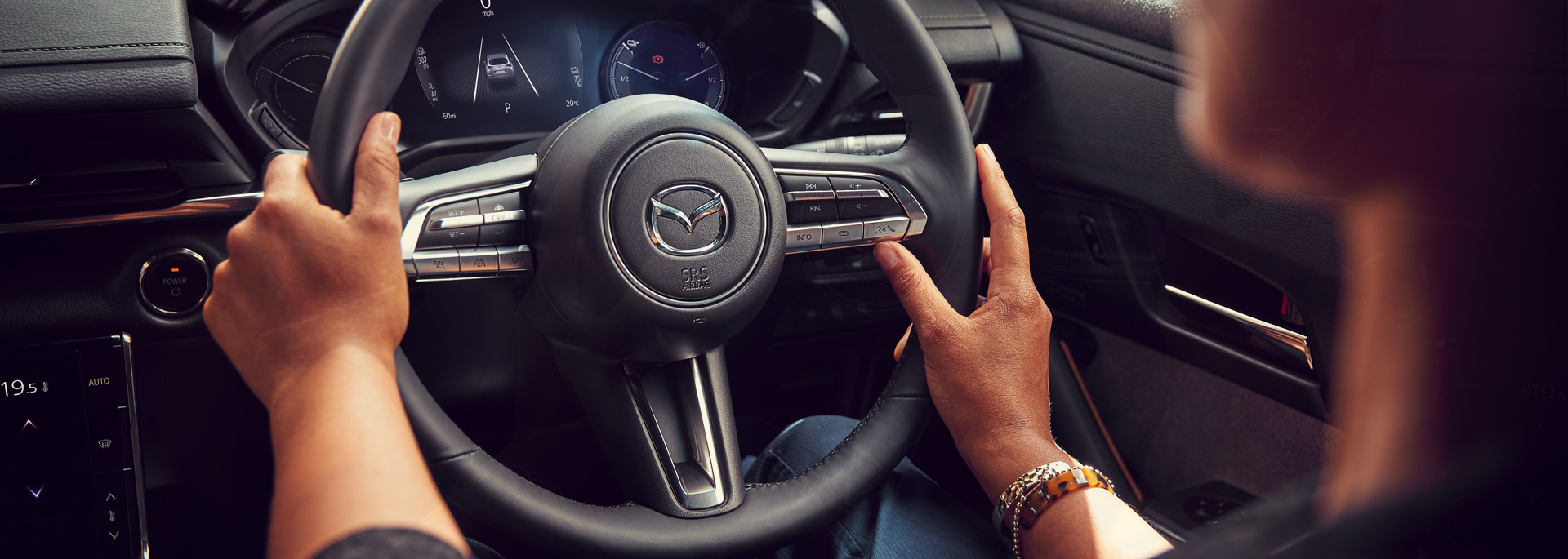 Hands on the Mazda MX-30 steering wheel.