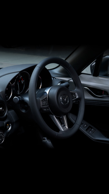 The leather wrapped steering wheel inside the Mazda MX-5
's cockpit.