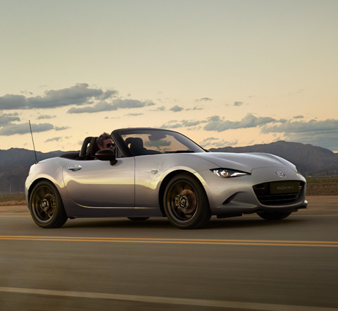 The Mazda MX-5
 Roadster driving on a road.