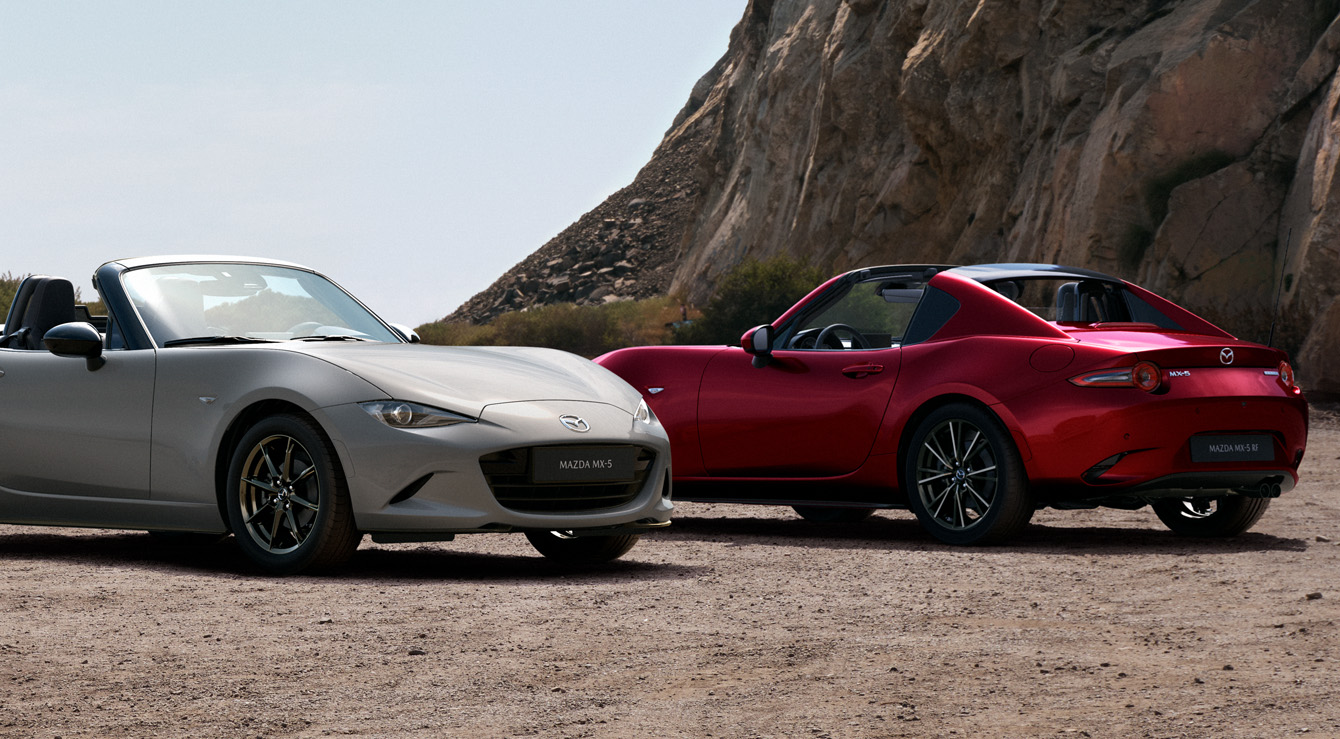 The Mazda MX-5 Roadster and the Mazda MX-5 RF parked next to each other at the beach.