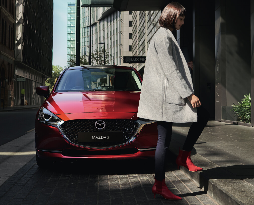 2022 Mazda2 in exterior colour soul red crystal with woman
