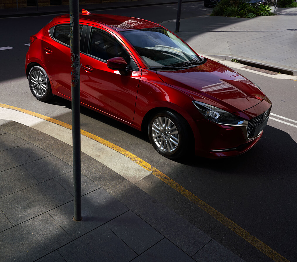Mazda2 car in soul red crystal exterior colour turning
